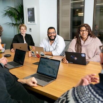 team meeting in an office with laptops out